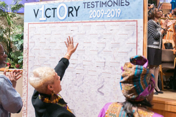 Congregation praising in front of 10th Anniversary testimony board