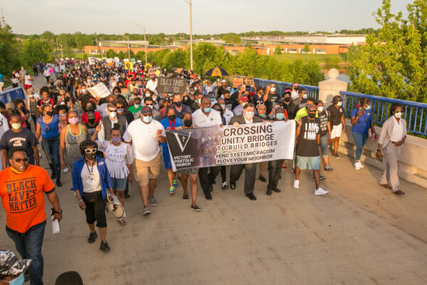 Marchers at Victory's Peace March holding signs